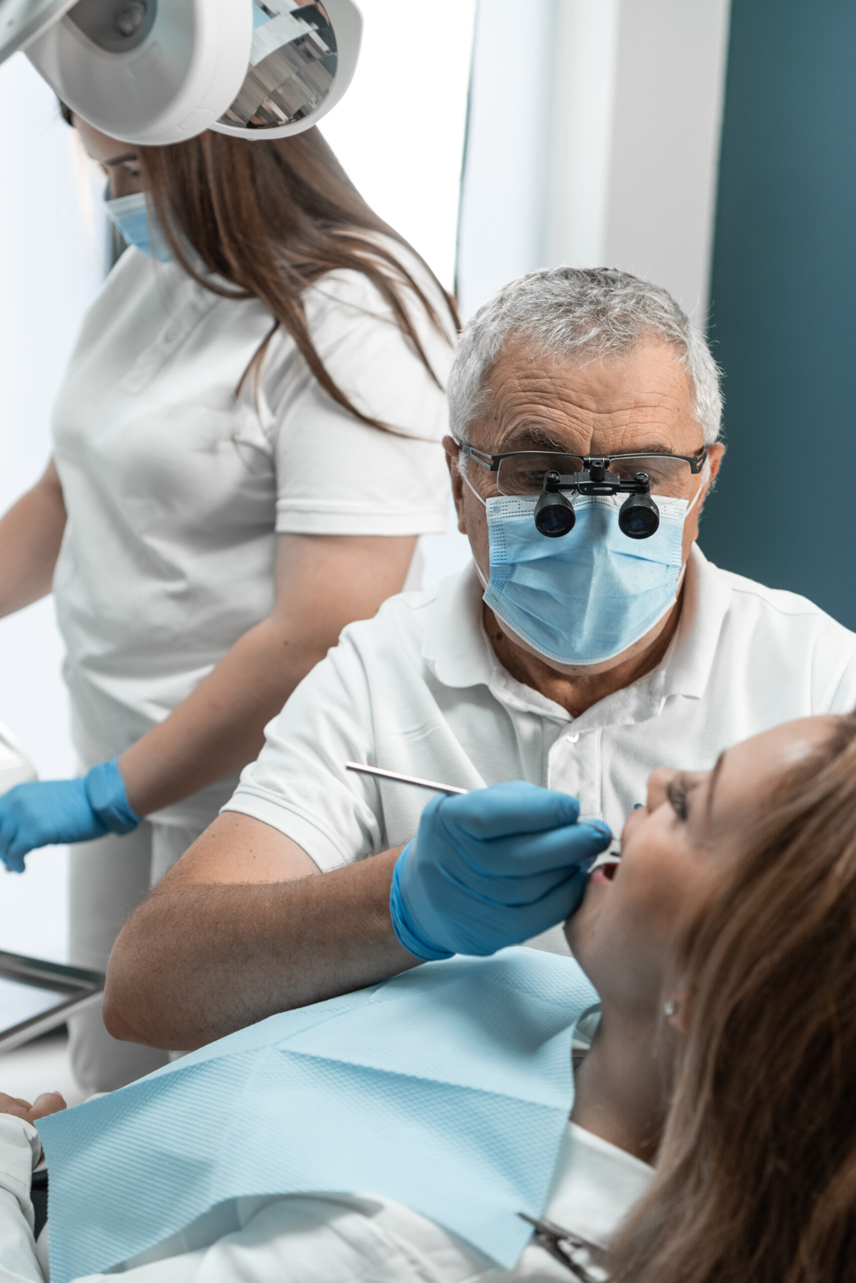 The dentist and his assistant perform effective teamwork during the treatment of the patient. Each of them fulfills its role, directing all efforts to improve the state of oral health. High quality photo